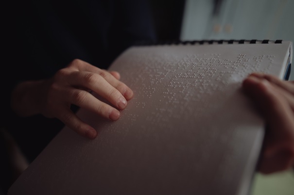Ruky nevidiaceho čítajú text v Braillovom písme