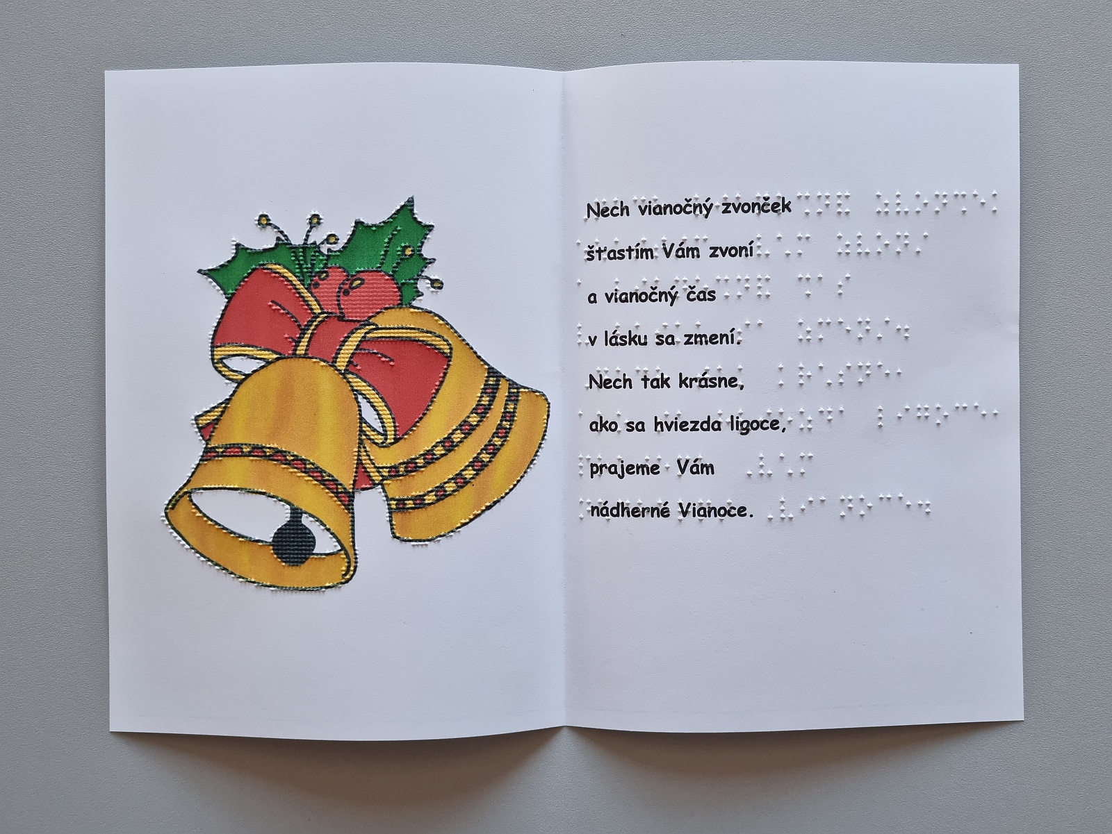 Vianočná pohľadnica, na farebnom obrázku sú vyobrazené dva zvončeky so stuhou. Text v braili aj čiernotlači.